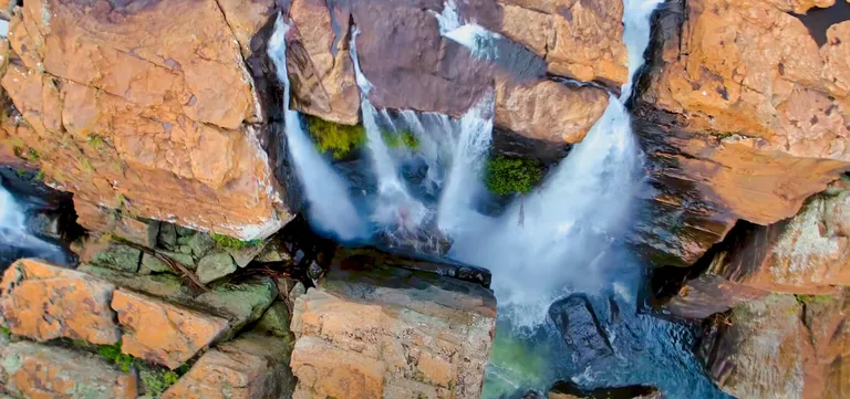 Aerial view of Amber Treur Falls spilling between orange rocks into the Treur River gorge, Mpumalanga