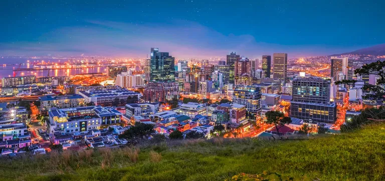 Cape Town's City Bowl and harbour lit up at night, with Bo-Kaap in the foreground