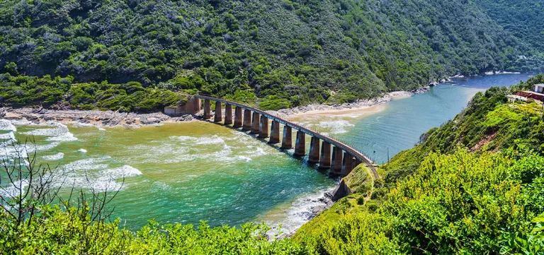 The historic Kaaimans River railway bridge curving across the river mouth between George and Wilderness, South Africa