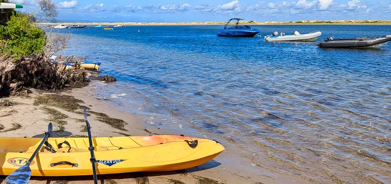 A yellow kayak on the sandy shore of the Keurbooms River estuary near Plettenberg Bay, South Africa