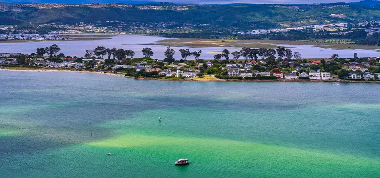 Turquoise sandbanks in the Knysna Lagoon off Leisure Island, with the far shore and hills behind, South Africa