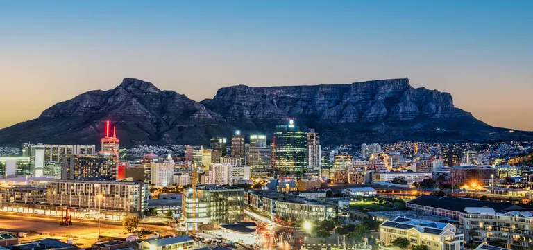 Table Mountain rising above the lights of Cape Town at night, Western Cape, South Africa