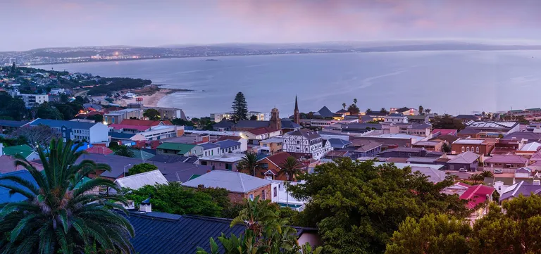 Mossel Bay at dusk, the town's rooftops and church spire above the wide curve of the bay, Garden Route, South Africa