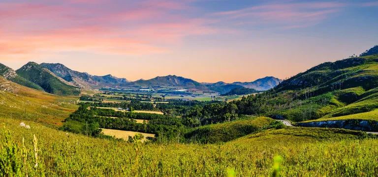 The Outeniqua Mountains ringing a valley of farmland and forest near George at sunset, Garden Route, South Africa