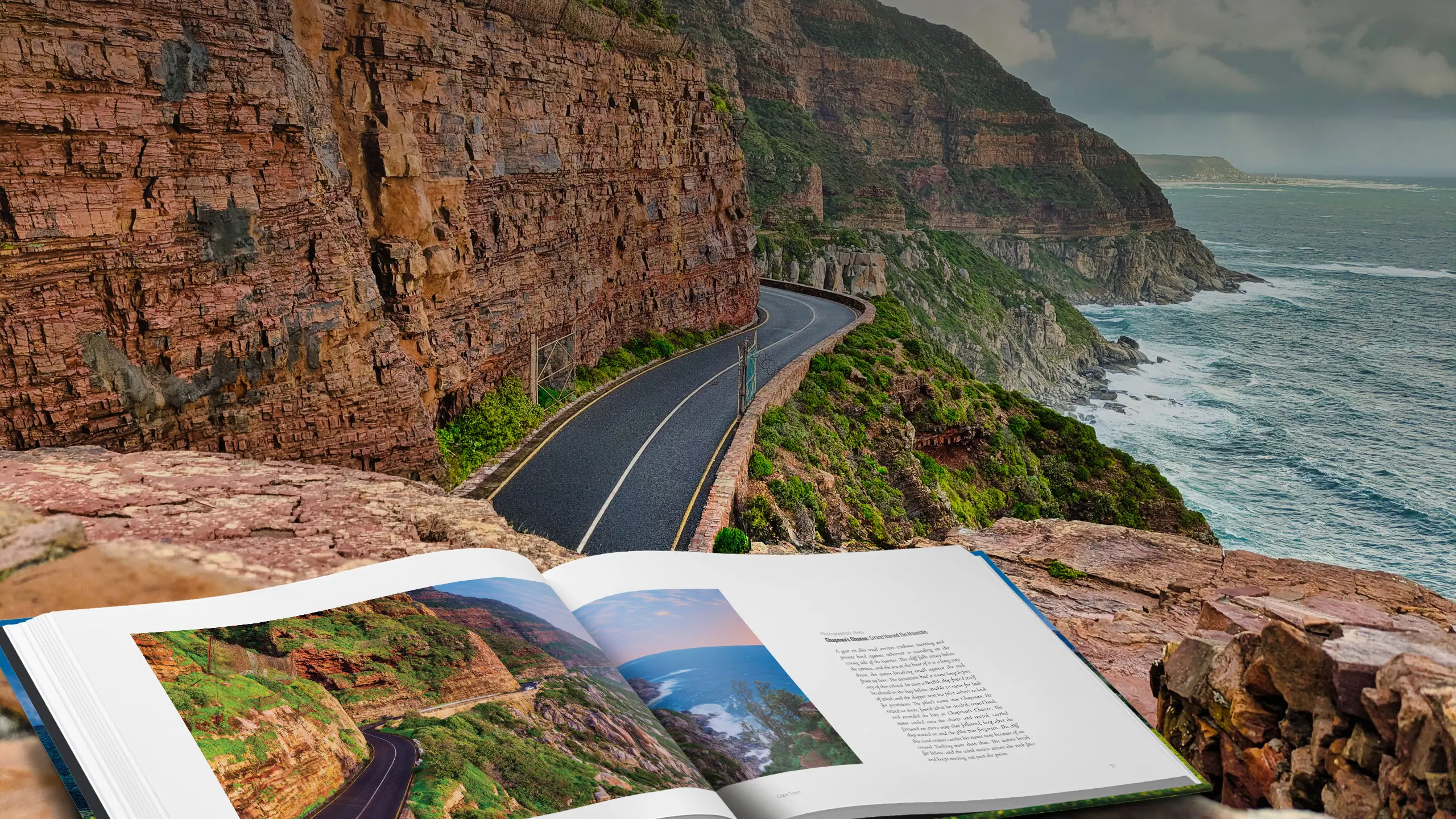 Edge of the Continent open at the Chapman's Peak spread, resting on a stone wall above the road where the photograph was taken